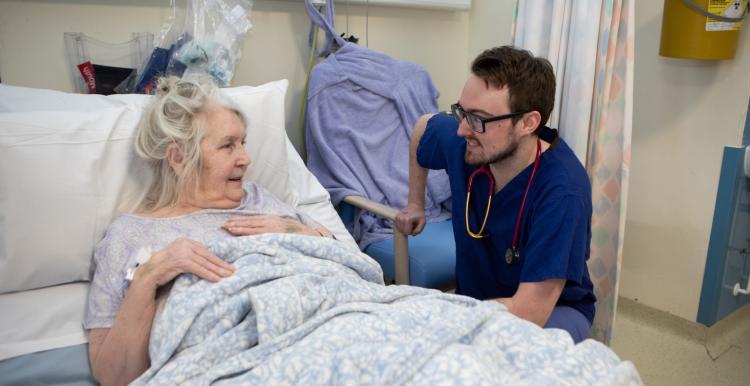 Health care staff speaking to a patient in hospital