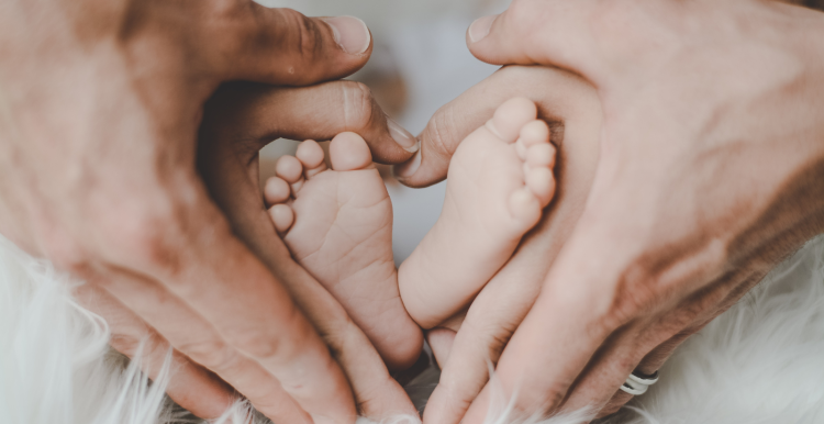 baby feet making a heart with parents hands.png