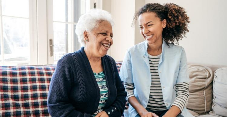 A younger and an older person sitting smiling