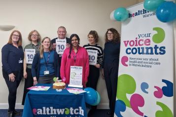 Healthwatch Warwickshire staff and 10 year anniversary display