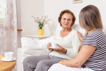 Older and younger ladies chatting with a cup of tea