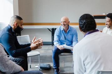 men sitting in a circle discussing