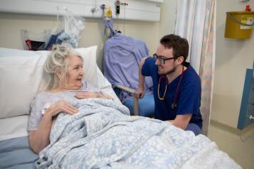 Health care staff speaking to a patient in hospital