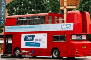 The cancer bus tour, showing the NHS logo on the side of the bus