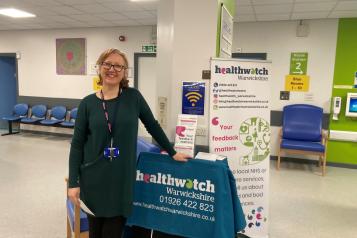 Staff member standing with our promotional banner