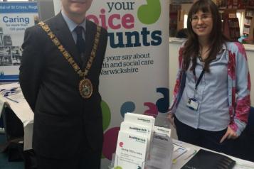 Mayor of Rugby standing with a member of staff at a stall at Rugby Library