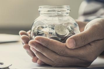 Hands holding a jar of coins