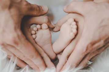 baby feet making a heart with parents hands.png