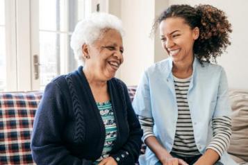 A younger and an older person sitting smiling