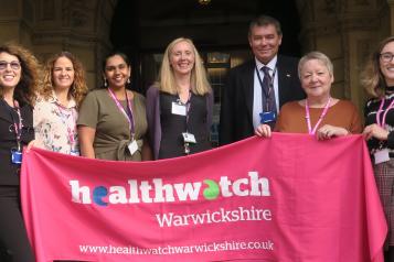 Staff team with Healthwatch Warwickshire banner