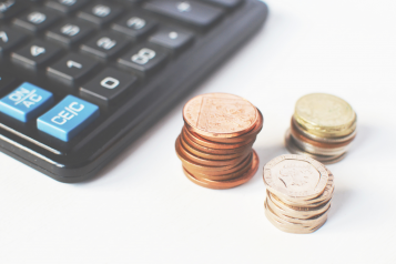 coins stacked up next to a calculator