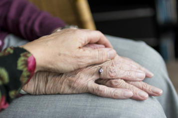 A hand resting on a pair of older hands