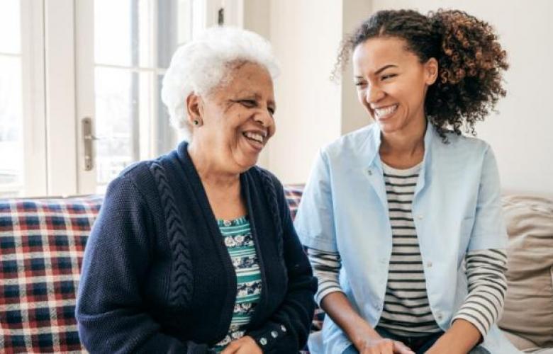 A younger and an older person sitting smiling