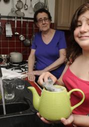 A young female carer helping her mum in the kitchen