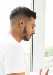 A man talking to a nurse in a hospital corridor